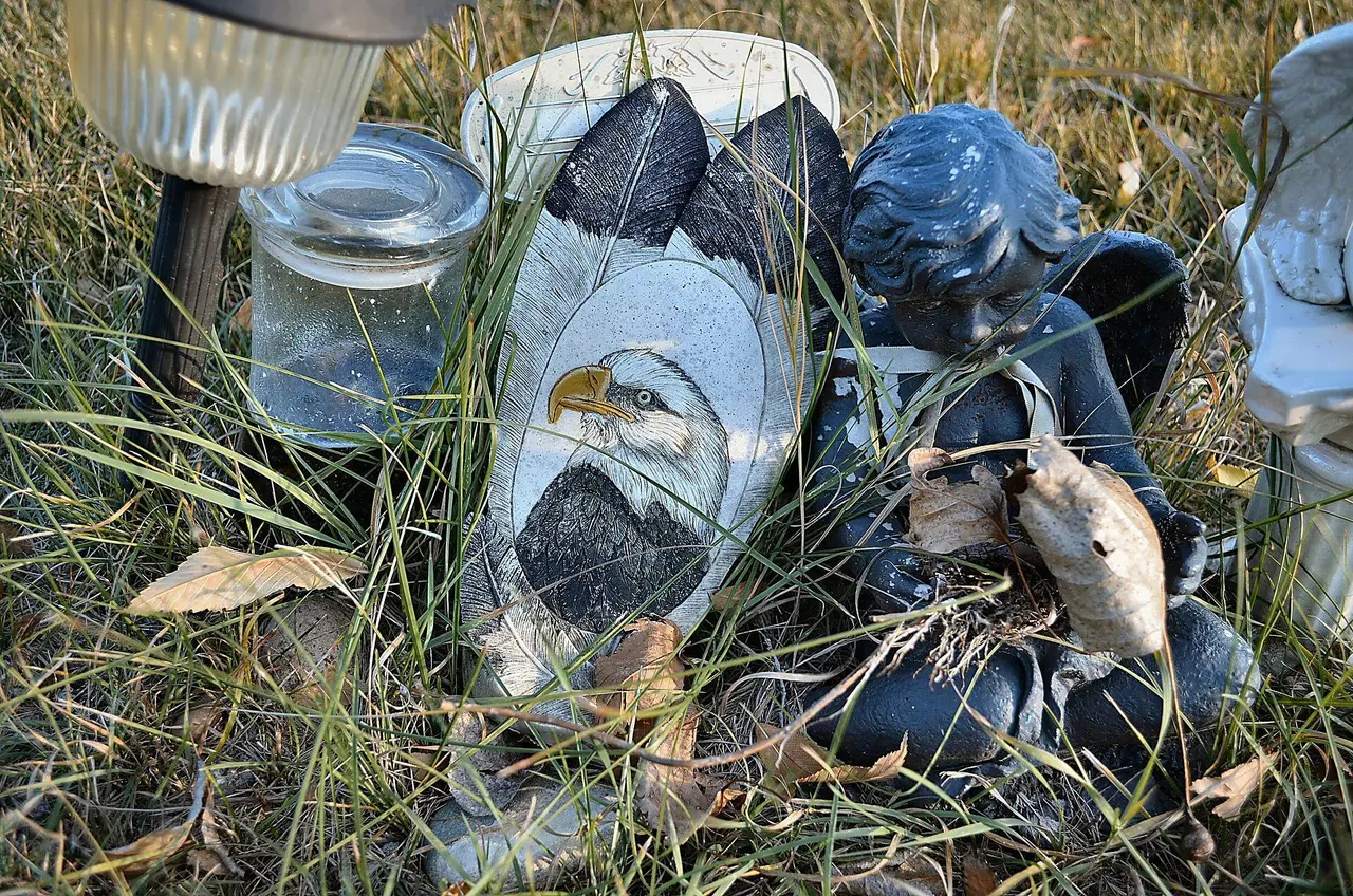 Eagle carving and cherub figure at a grave in Lebret, 2011