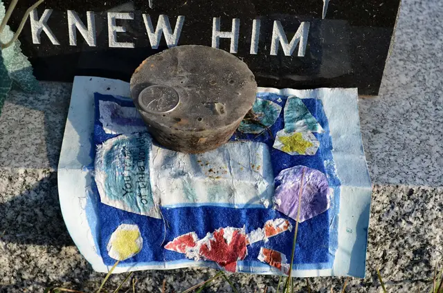 Note and objects on a grave marker